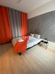a bedroom with a bed with an orange blanket on it at Le Romainvillois-Terrasse aux portes de Paris in Romainville +15 photos