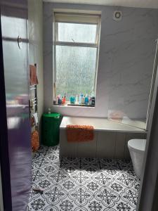 a bathroom with a bath tub and a window at Rosie Cosy House Cricklewood in London