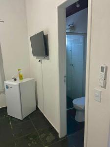 a bathroom with a toilet and a tv on the wall at Pousada Recanto da Luísa in Paraty +36 photos