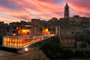 a view of a building with a clock tower at sunset at Casa Torre Borgo dei Borghi in Peccioli