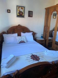 a bedroom with a large bed with white sheets at Villa Pogradeci in Pogradec