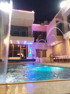 ein Schwimmbad mit Springbrunnen vor einem Gebäude in der Unterkunft Vienna Villa for you in Al Qasţal + 13 Fotos