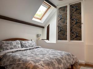 a bedroom with a bed and two windows at La Meltiere Sleeps 4 with Garden in Courcité