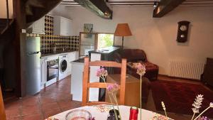 a kitchen and living room with a table and a dining room at La Meltiere Sleeps 4 with Garden in Courcité +24 photos