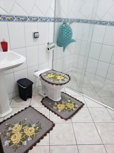 a bathroom with a toilet with flowers on it at La Linda playa in Guaratuba