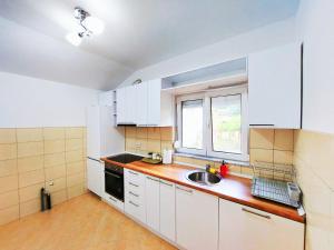 a kitchen with white cabinets and a sink at Indijano Apartment in Ohrid