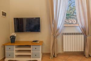 a room with a table and a tv and a window at Windrose Blue Home in Sant'Ermo