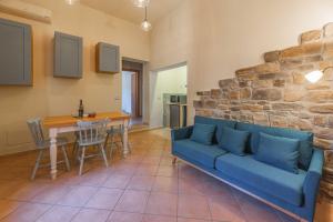 a living room with a blue couch and a table at Windrose Blue Home in Sant'Ermo