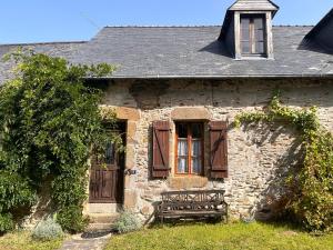 an old stone house with a bench in front of it at La Meltiere Sleeps 4 with Garden in Courcité