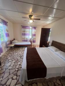 a bedroom with two beds and a ceiling fan at Cozy Family Inn in Port Antonio