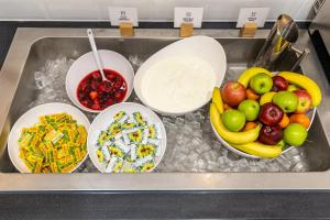 a tray of food with bowls of fruit on it at Holiday Inn Express London Croydon, an IHG Hotel in Croydon