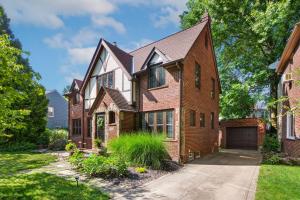 a brick house with a garage in a yard at The Knocking Bird- Mins to CLE Clinic in Cleveland Heights