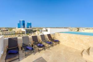 a rooftop patio with chairs and a tennis court at Annitchka Mansions - Apartment in central Malta in Birkirkara