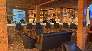 a bar in a restaurant with leather chairs at Le Suisse Spa in Santa Lucía Milpas Altas