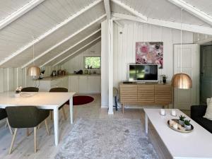 a living room with a table and a tv at 8 person holiday home in Gilleleje-By Traum in Gilleleje