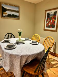 a dining room with a table with chairs and flowers at Madeleines place in Galway +10 photos