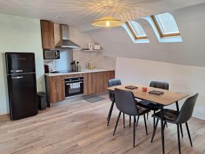 a kitchen with a table and chairs in a kitchen at Faubourg des voyageurs 7 - T2 climatisé 2 personnes - proche axe autoroute in Saran