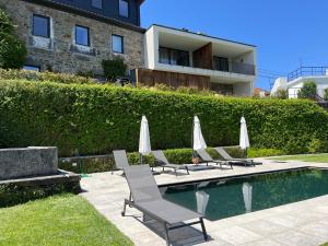 Vila MarimFLH Douro Casa do Mártir的泳池旁边的一组椅子和遮阳伞