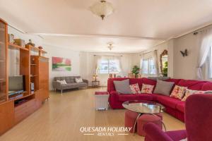 a living room with a red couch and a tv at Stunning Central Villa Rosa in Ciudad Quesada Rojales Spacious 4-Bedroom Retreat with Private Pool in Ciudad Quesada