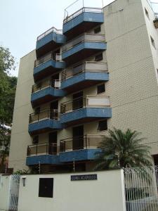 a tall building with blue balconies on the side of it at Apartamento na Praia Grande em Ubatuba in Ubatuba