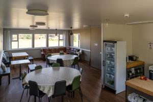 a room with two tables and chairs and a kitchen at Vogar Travel Service in Myvatn