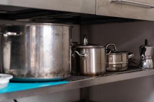 two large pots and pans on a shelf in a kitchen at Vogar Travel Service in Myvatn