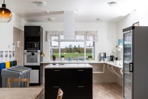 a kitchen with black and white appliances and a window at Vogar Travel Service in Myvatn