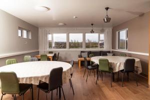 a room with two tables and chairs and windows at Vogar Travel Service in Myvatn
