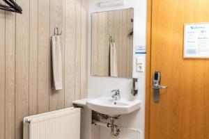 a bathroom with a sink and a mirror at Vogar Travel Service in Myvatn