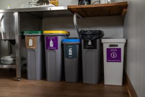 four trash cans are lined up under a counter at Vogar Travel Service in Myvatn