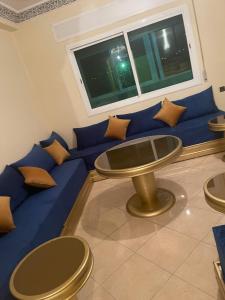 un canapé bleu avec des oreillers et une table dans une pièce dans l'établissement Appartement à Tanger, à Tanger