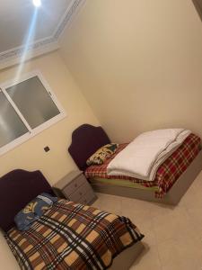 deux lits jumeaux dans une chambre avec fenêtre dans l'établissement Appartement à Tanger, à Tanger