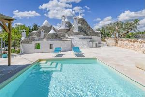 a house with a swimming pool in front of a house at Trullo Matilde in Martina Franca