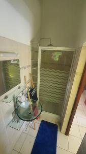 a room with a glass table and a shower at Au cœur de douenel bouillante cheques vacances acceptées in Bouillante