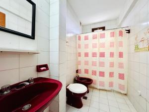 a bathroom with a red sink and a toilet at Departamento A Mar in Mar del Plata