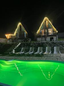 a house with chairs and a pool at night at Morning Star Kazbegi in Stepantsminda