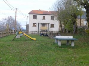 a playground with a slide and a table in a yard at Gîte en pierres avec cour et 3 chambres, au cœur d'un village proche de Langeac - FR-1-582-233 in Pinols
