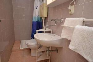a bathroom with a sink and a toilet and a shower at Apartments with parking space Murvica, Brac - 23462 in Bol +12 photos