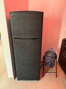 een zwarte koelkast in een kamer met een vuilnisbak bij Bienvenidos a tu segundo hogar! in Altamira