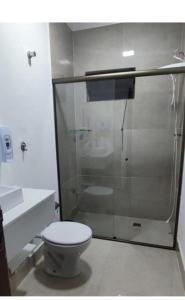 a bathroom with a toilet and a glass shower at WK Green Vine in Santa Rita do Sapucaí