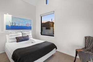 a bedroom with a bed and a window and a chair at Overdale Oasis in Christchurch