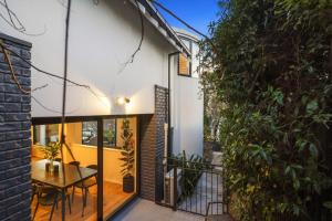 a dining room with a table on a balcony with a building at Overdale Oasis in Christchurch
