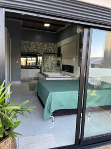 a bedroom with a green bed on a patio at Terra Santa - Condomínio Monte Hermon in Trindade