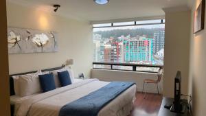 a bedroom with a large bed and a large window at BlueZone Apartments in Quito +107 photos