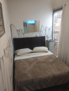 una camera da letto con un grande letto e un grande specchio di Recanto das Pedras - Suíte 2 a São Thomé das Letras Altre 21 foto