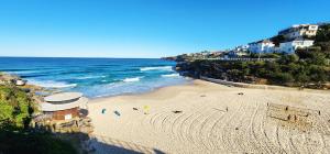an overhead view of a beach with people on it at Coastal Luxury overlooking Tamarama Beach in Sydney