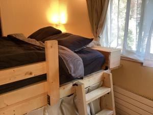 a bedroom with a wooden bunk bed with a window at 貸切別荘Madoyaのお宿 Loiseau bleu Iizuna in Chūsha