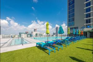 a row of lounge chairs with umbrellas and a pool at Apartment in Miami downtown in Miami