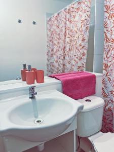 a bathroom with a white sink and a pink towel at Departamento céntrico, acogedor y bien equipado in Concepción