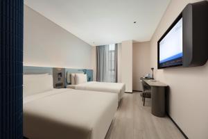سرير أو أسرّة في غرفة في Atour Light Hotel Wuxi Taihu Lake Expo Center Financial Street